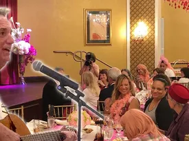 Guests smiling while Alan performs nearby