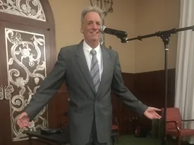 Alan Cohen performing with a microphone
