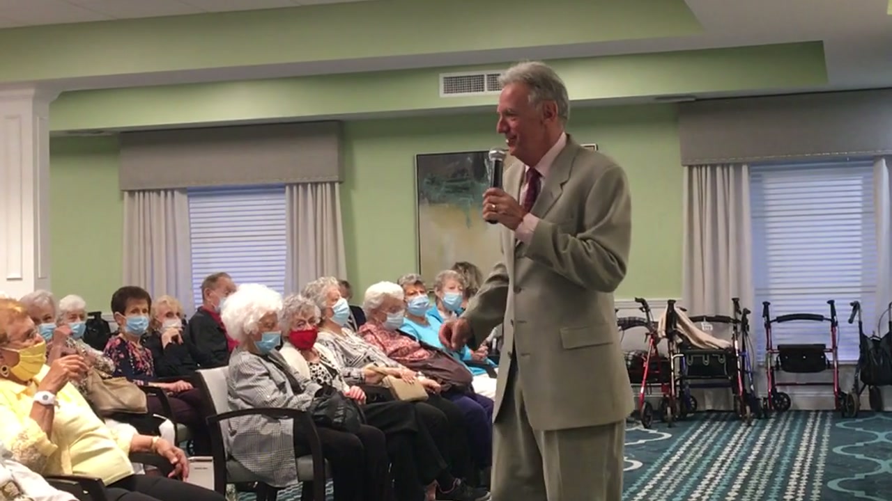Alan performing beside a full senior-community audience